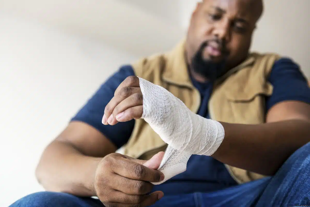 A Louisiana man wrapping a bandage around his hand after suffering a personal injury.