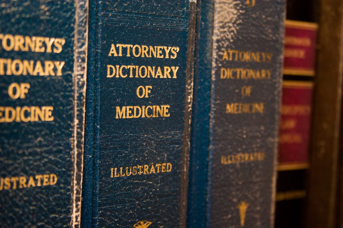 Close-up view of manuals on a shelf titled “Attorneys’ Dictionary of Medicine”
